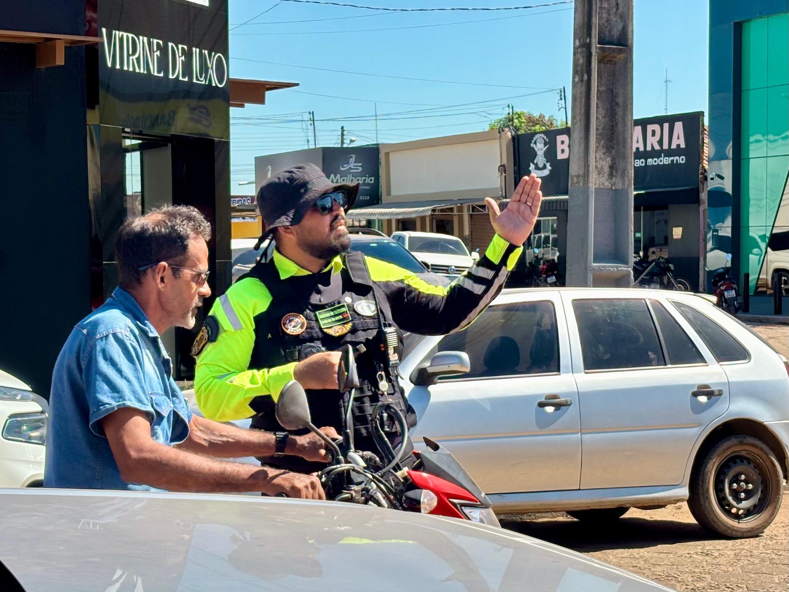 Agente de trânsito orientando motociclista em via pública de Rio Maria