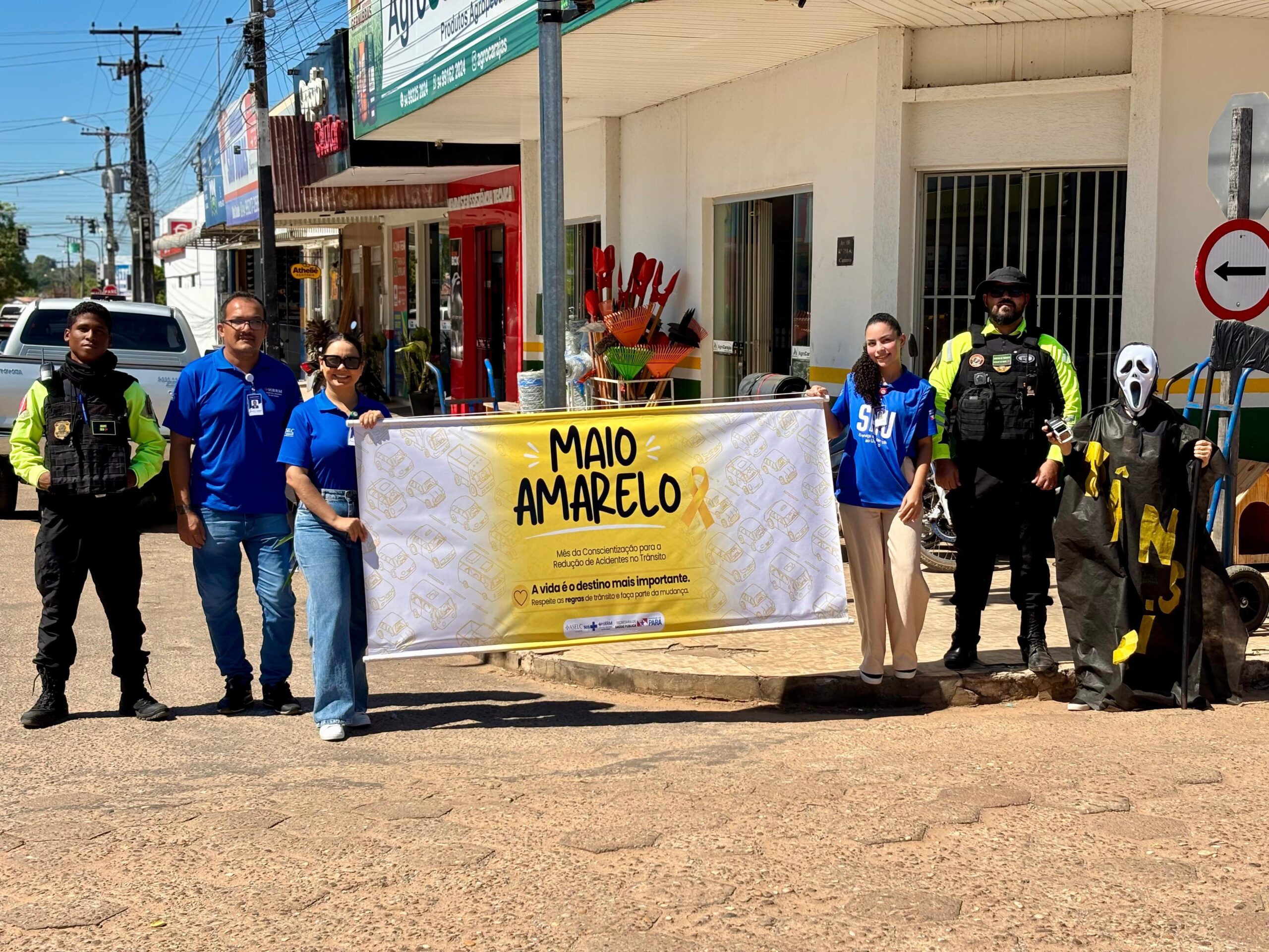 Equipe do DMT e do HRRM reunida em sala com banners da campanha Maio Amarelo